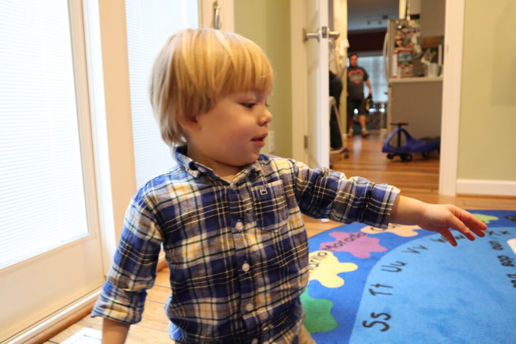 Young boy reaching for a toy. Not a composed photo.