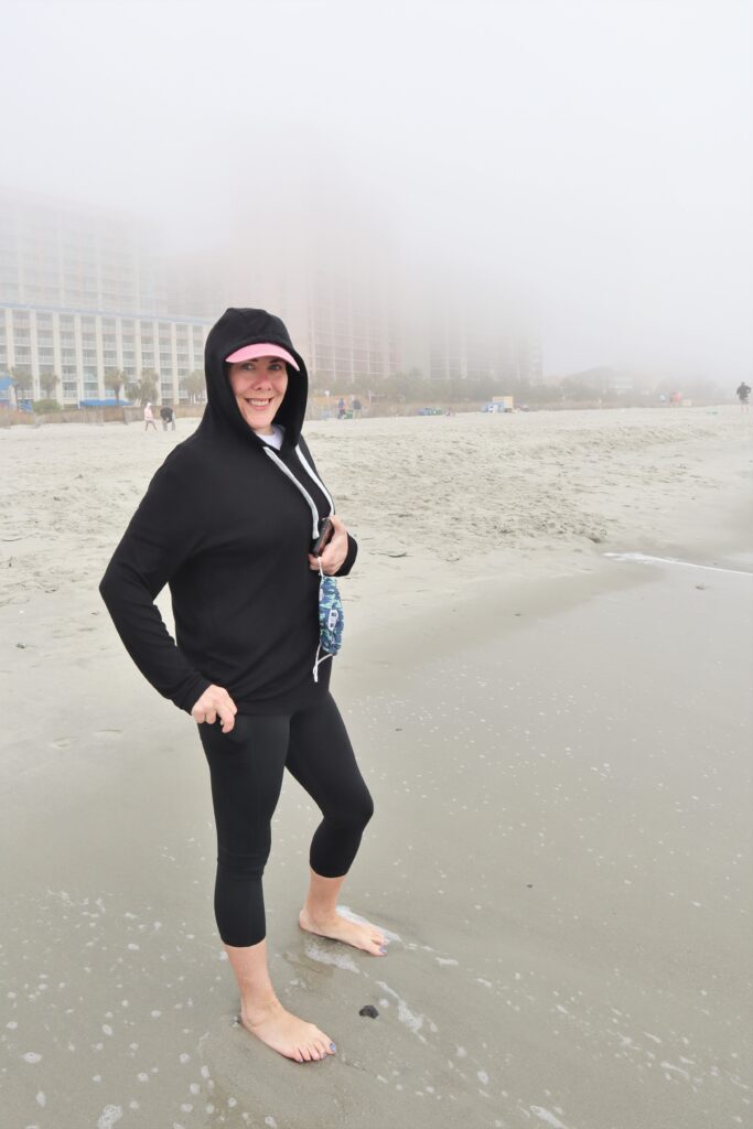 Woman on a foggy beaching wearing a hoodie. Finished photo after applying ROT